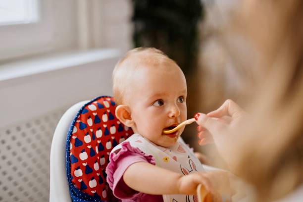 istock Mother feeding baby in the kitchen 1332520286