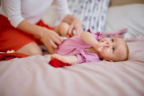 istock Mother changing her baby diaper 1332520307
