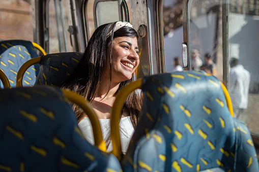 woman traveler smiling in the colorful bus while getting to know the city, its architecture and history