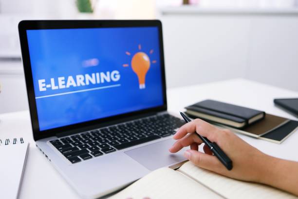 istock E-learning Education Internet Networking . Young businesswoman sitting at table used laptop with inscription on screen e-learning. Online education e-learning. 1332521835