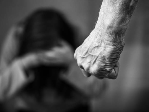 Domestic violence mans clenched fist Domestic violence man against woman clenched fist black and white image abuse stock pictures, royalty-free photos & images