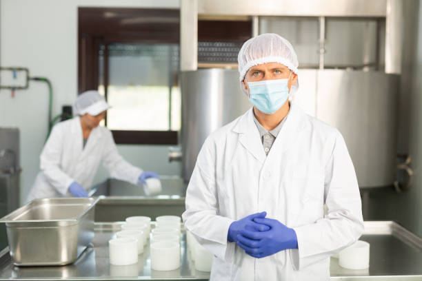 istock Confident cheesemaker in mask standing in cheese shaping workshop 1332526997