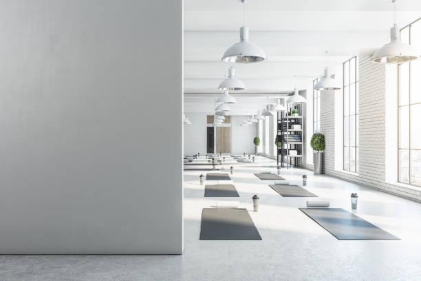 Modern bright white yoga studio gym interior with empty brick wall, window and city view. Mock up, 3D Rendering.