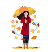 istock Smiling woman holding umbrella under the rain of leaves 1332528482
