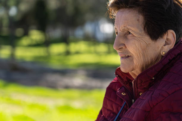 90 year old white woman in the park laughing and pensive. - 80 year old imagens e fotografias de stock