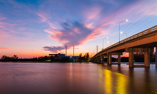 bridge over river in the evening. The light from the lamp to the reflector surface,Container Terminal in Hamburg, Germany. Bridge is called Koehlbrandbruecke - a bridge about the harbor.