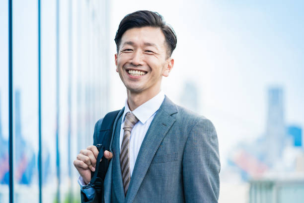 un homme d’affaires qui se déplace avec le sourire - japonais photos et images de collection