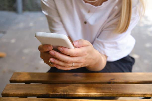 istock The girl is holding a modern smartphone, sending a text message or using an application on her mobile phone. Make memories using your smartphone. Smartphone close-up 1332530917