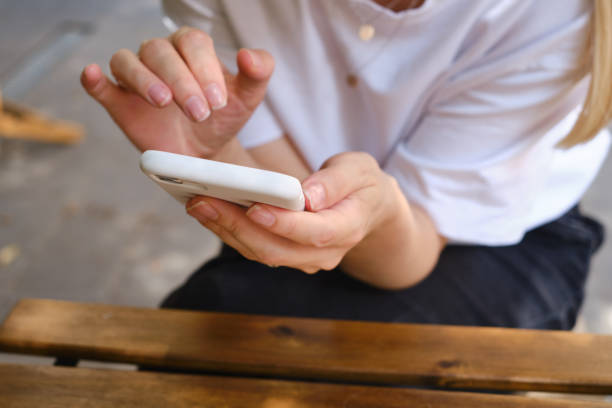 istock The girl is holding a modern smartphone, sending a text message or using an application on her mobile phone. Make memories using your smartphone. Smartphone close-up 1332530955