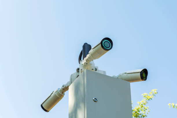 istock Security cameras and a Wi-Fi station installed on a pole in a public place. Surveillance and security technologies. 1332532032