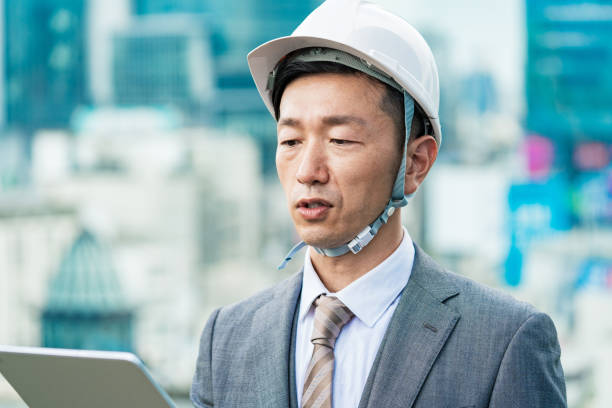 istock A businessman wearing a helmet and looking at a tablet PC 1332532207