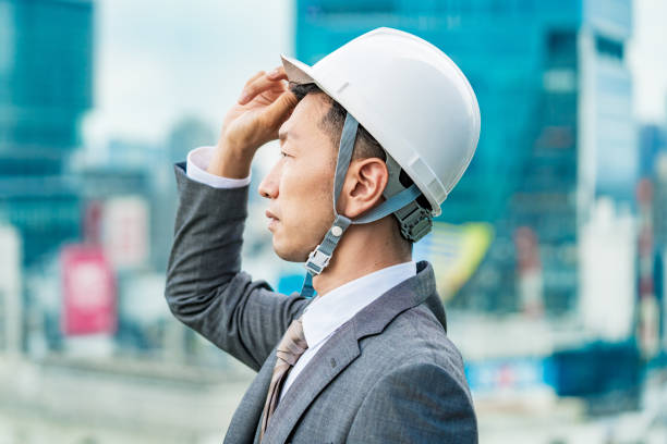 A businessman wearing a helmet