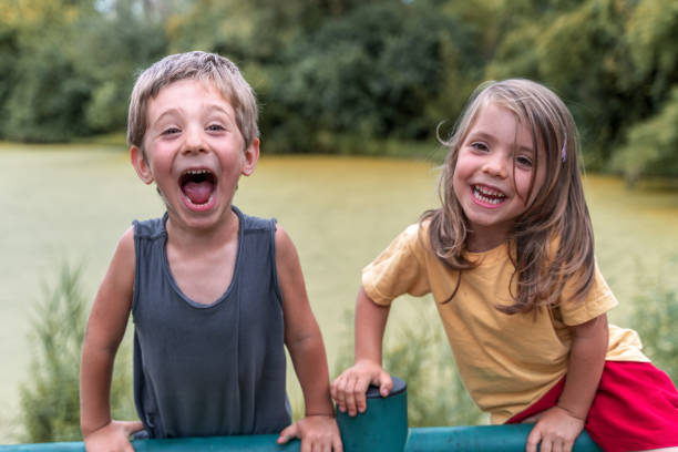 Beautiful boy and girl having fun on a river during hot summer day.