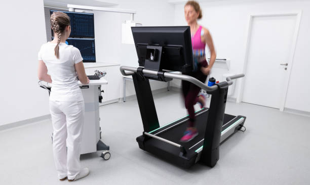 Woman Running On The Treadmill Ergometer During A Cardiopulmonary Stress Test Woman running on the treadmill ergometer during a cardiopulmonary stress test. Healthcare and medicine concept. stress test stock pictures, royalty-free photos & images