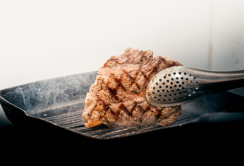 Close up wagyu beef striploin steak with pepper on dark pan\nhokubee\nphotography