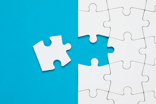 Jigsaw puzzle on blue background with copy space