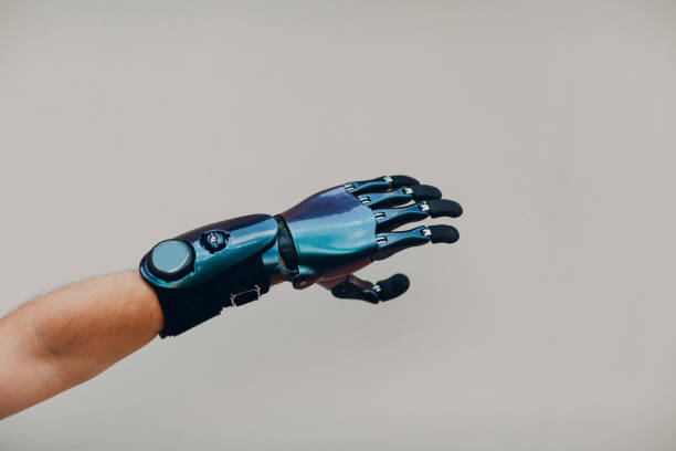 istock Disabled man with artificial prosthetic hand close up hand against gray background. 1332542014
