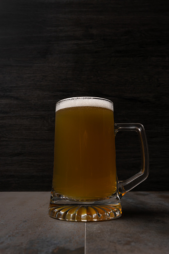 beer jar with foam on wood table background