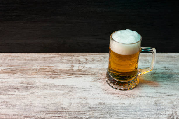 istock beer jar with foam on wood table background Beer Fest 1332543528