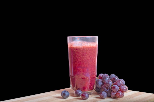 jus de raisin frais avec des raisins noirs et rouges sur une table en bois sur un fond sombre - arun photos et images de collection