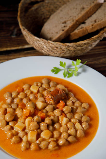 Chickpea stew dish, cocido madrileño. Rustic look. Chickpea stew dish, cocido madrileño. With beef, sausage (chorizo), bacon, carrots and bread. winter rye stock pictures, royalty-free photos & images