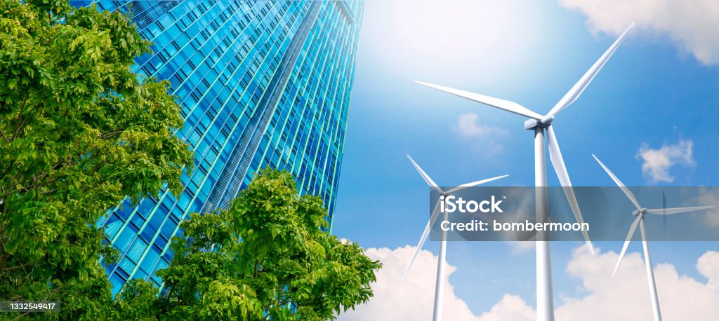 Modern high-rise buildings are powered by wind turbines and green nature. Modern high-rise buildings are powered by wind turbines. and the fresh air from the trees Sustainable Resources Stock Photo