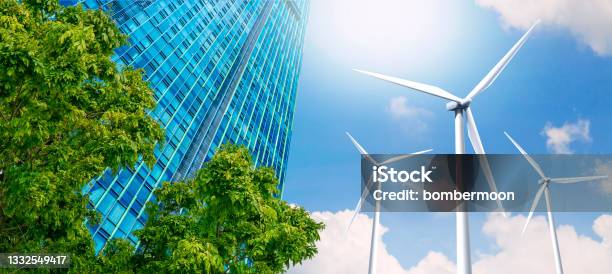 Modern Highrise Buildings Are Powered By Wind Turbines And Green Nature Stock Photo - Download Image Now