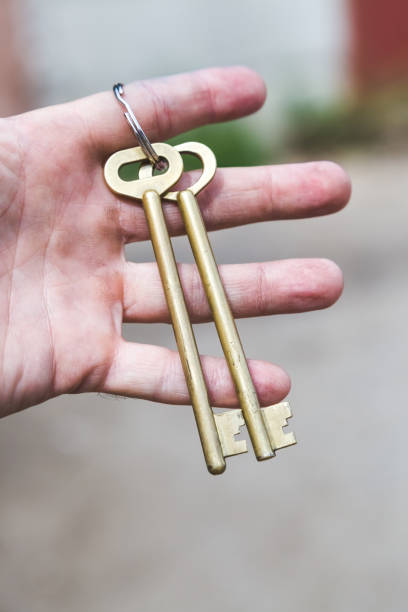 deux grandes clés - human hand key giving carrying photos et images de collection