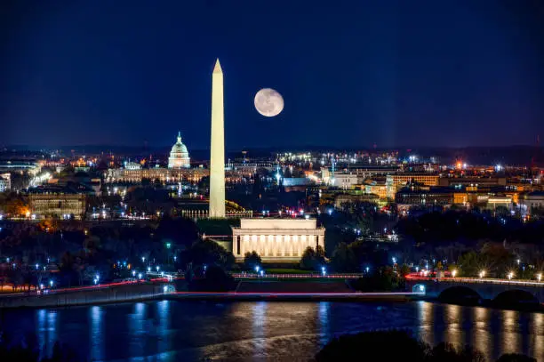 Long Exposure picture of illuminated Washington DC at night with the US. Capitol, Washington Monument and the Lincoln Memorial visible with a waning gibbous moon