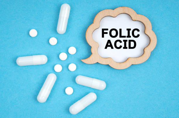파란색 배경, 알약과 비문이 있는 접시에 - folic acid - 엽산 뉴스 사진 이미지