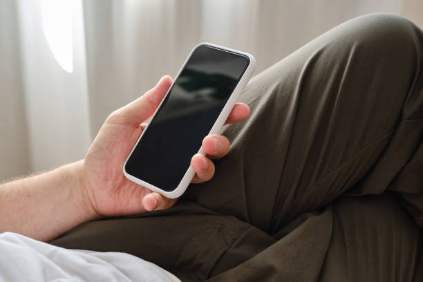 istock A man is holding a modern smartphone, sending a text message or using an application on his mobile phone. Gadget addiction. Smartphone close-up. Focus on the phone screen 1332551482