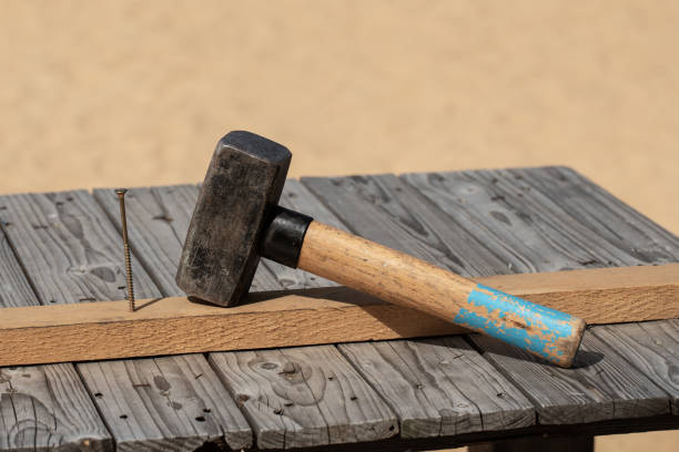 istock Hammer and nail on the old wood worktable 1332551867