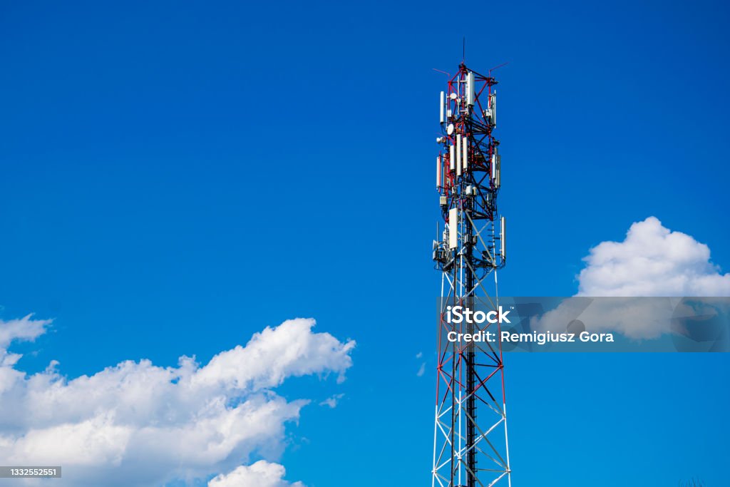 Telecommunication tower of 4G and 5G cellular. Macro Base Station. 5G radio network telecommunication equipment with radio modules and smart antennas mounted on a metal against cloulds sky background. Broadcasting Stock Photo