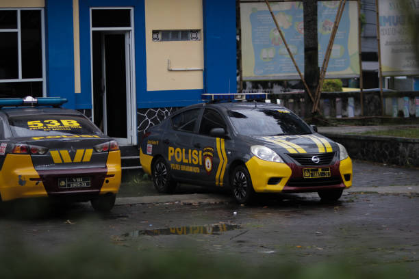 coche de la policía indonesia aparcado frente a un puesto de guardia en la ciudad de sukabumi - cañón de agua fotografías e imágenes de stock