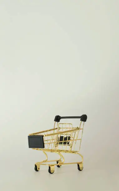 Photo of Shopping trolley with free space for text. Black friday concept. Sale, deal and discount. Closeup, copy space.