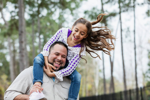 istock Hispanic girl on father's shoulders, playing, laughing 1332557692