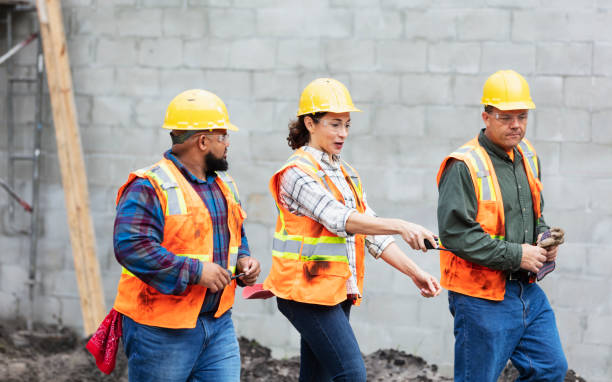istock Hispanic woman directs construction workers at job site 1332558049