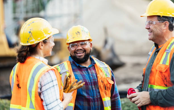 tres trabajadores multiétnicos de la construcción charlando - oficio fotografías e imágenes de stock