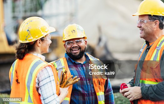istock Three multi-ethnic construction workers chatting 1332558192