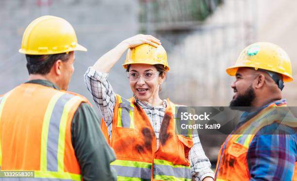 Hispanic Woman And Two Men Workers At Construction Site Stock Photo - Download Image Now