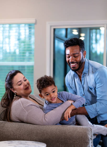 istock Multi-ethnic family with boy sitting on sofa at home 1332558334