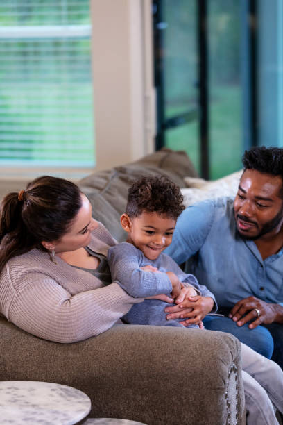 istock Multi-ethnic family with boy sitting on sofa at home 1332558346