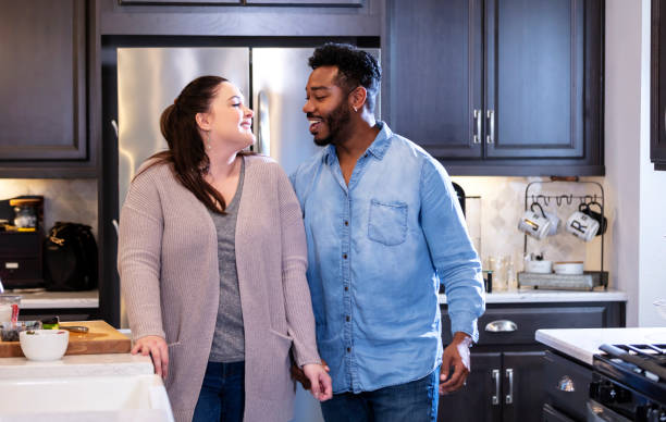 istock Multi-ethnic couple at home in the kitchen talking 1332558906