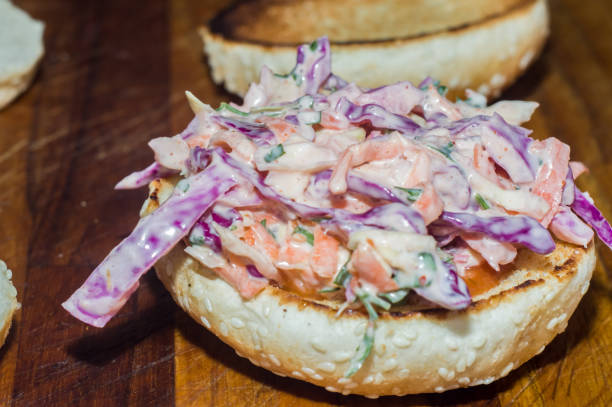 bread on a wooden board with coleslaw salad