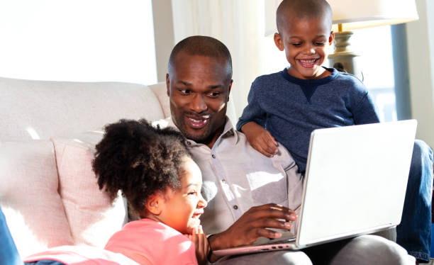 istock Father working at home on laptop, laughing with children 1332565600