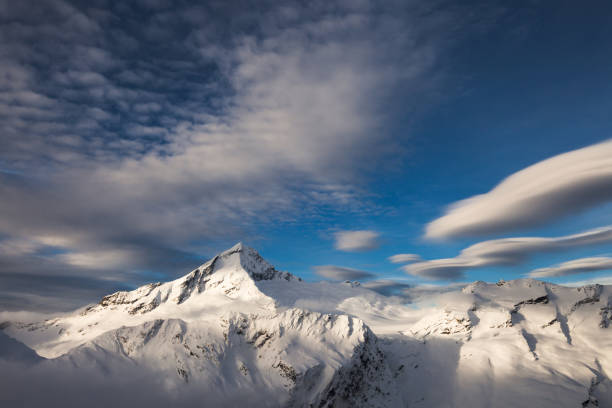 Snowcapped mountain peaks looking out through the fog.