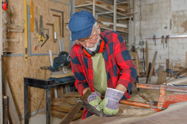 istock A Senior Casually Dressed Bearded Carpenter is Working in a Workshop and Clenching a Wooden Board Using a Clamp. 1332574568