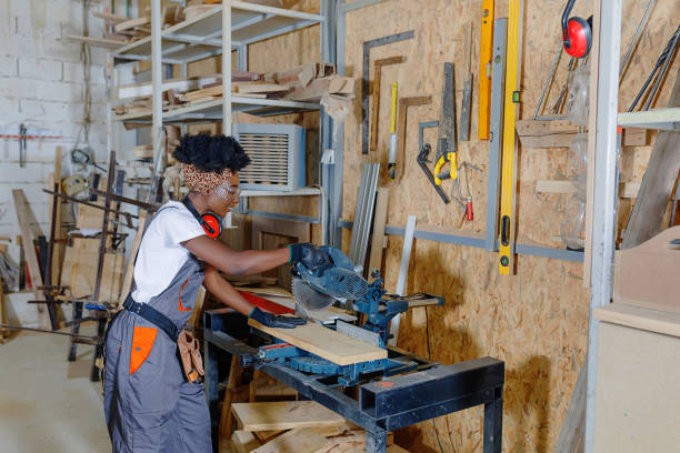 istock African-American Woman Carpenter is Working on a Circular Saw in Carpentry Workshop. 1332575291