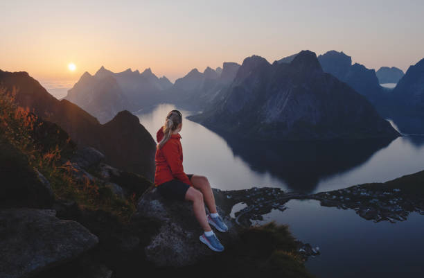 istock Young woman overlooking sunset in Lofoten. 1332575377