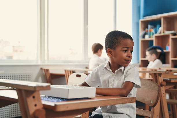 istock Calm boy behaving quietly at the school lesson 1332576699